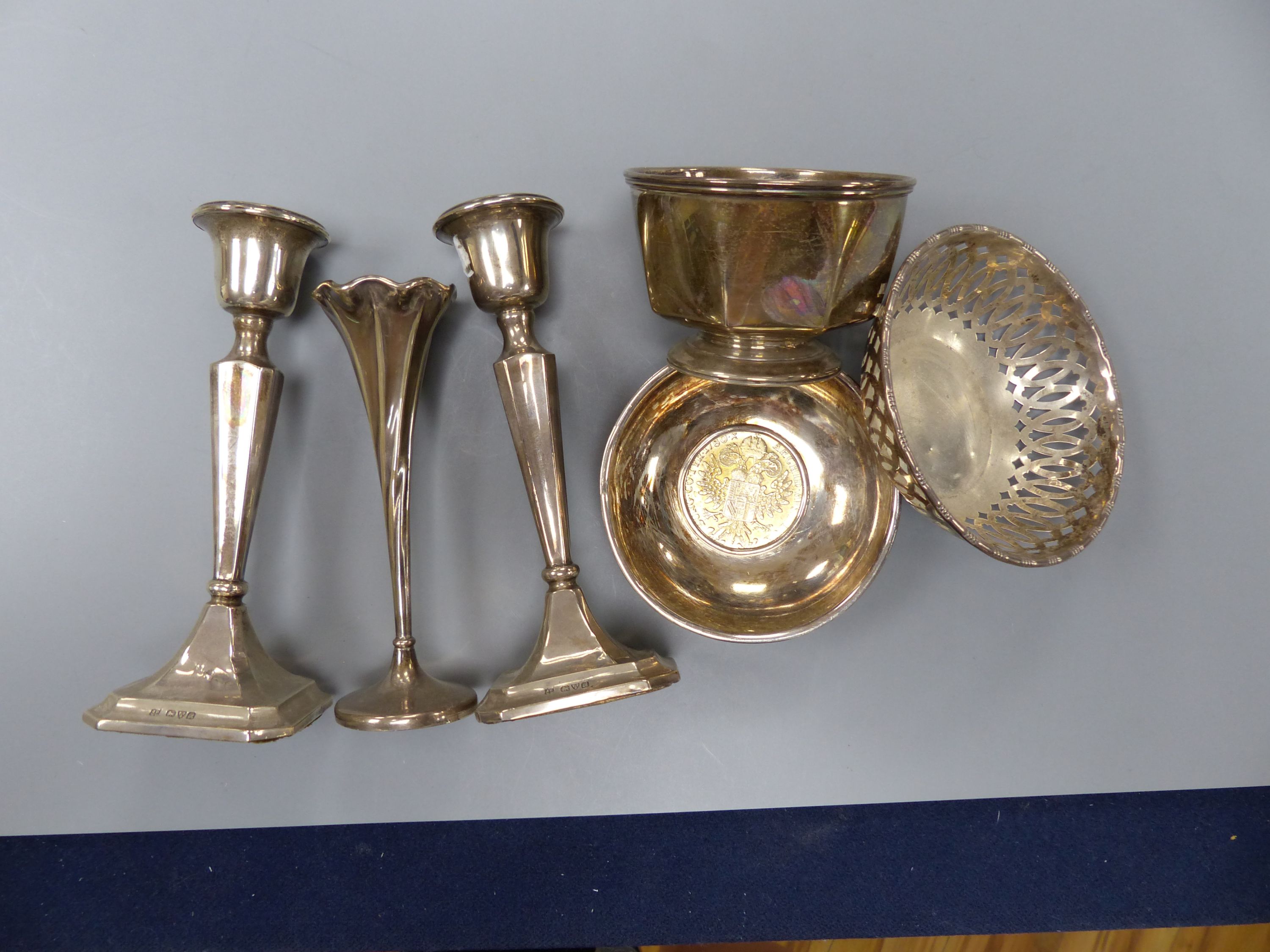 A pair of George V silver mounted candlesticks, 15.2cm, a silver posy vase, silver bowl, silver pierced dish and a 925 inset coin dish.